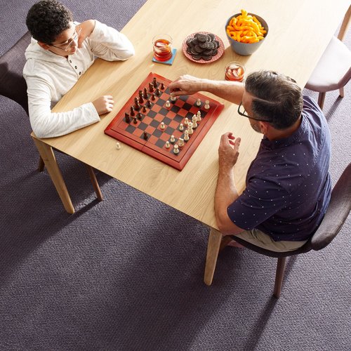 A couple playing a board game in a living room with carpeted floors
